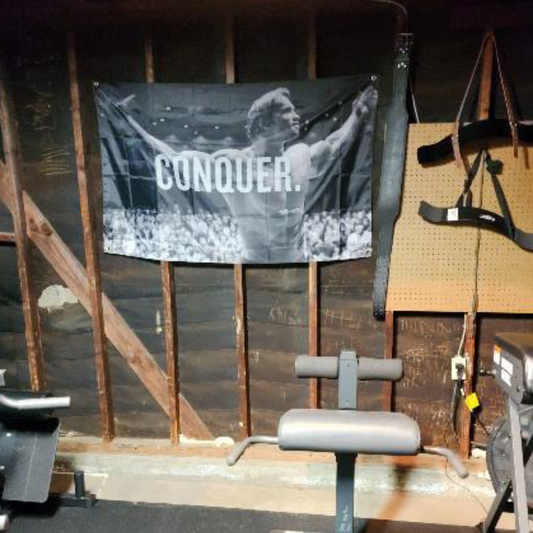 Arnold Schwarzenegger 'Conquer' Flag by Trident Flags - Inspirational Gym Decor for Fitness Motivation.